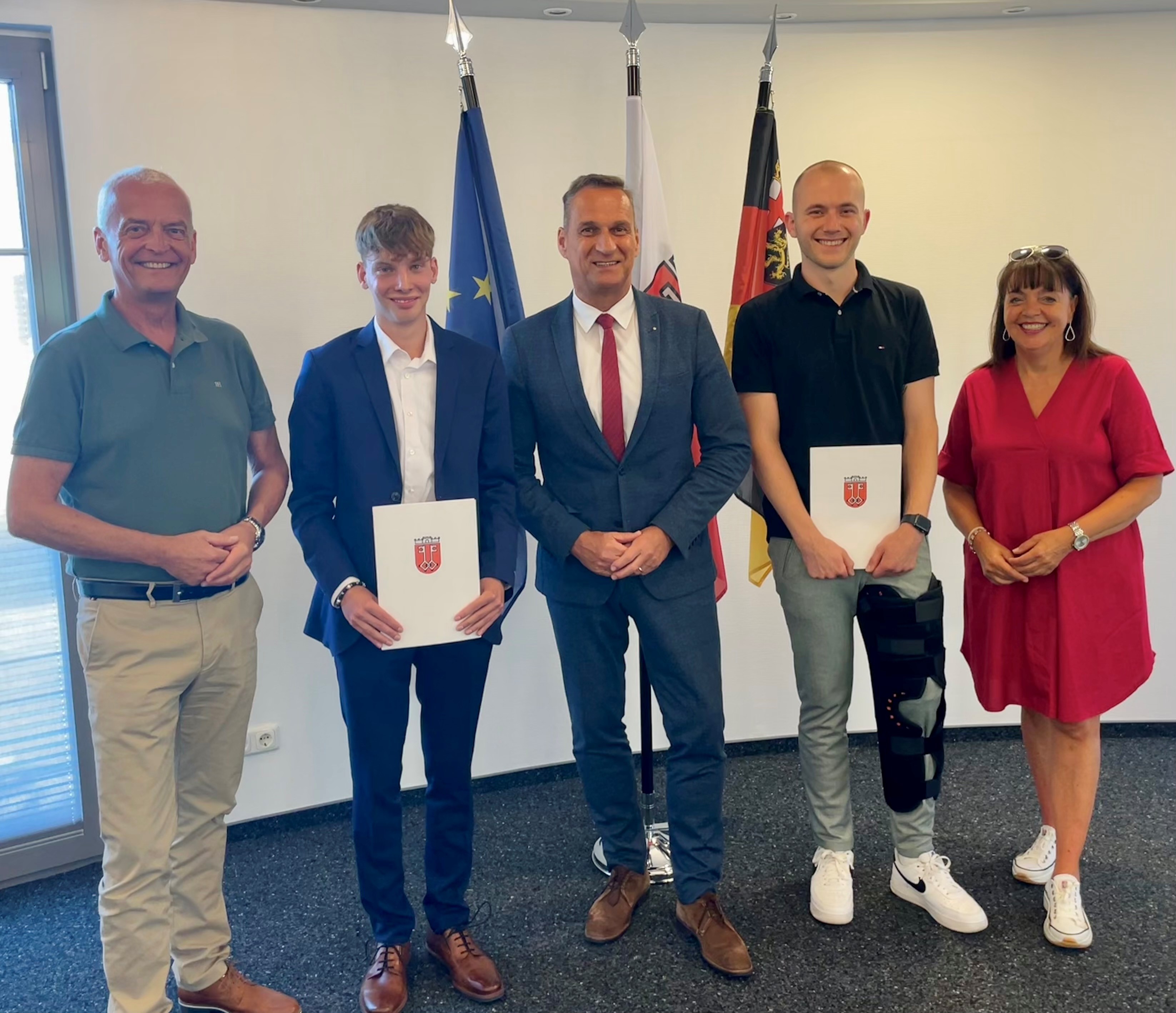 Das Foto zeigt die beiden Anwärter Leon Becker und Jonas Böhmer nach der Übergabe der Ernennungsurkunden mit Bürgermeister Rodenkirch, Büroleiter Rainer Stöckicht und Personalratsvorsitzende Christiane Schmitz-Hayer.