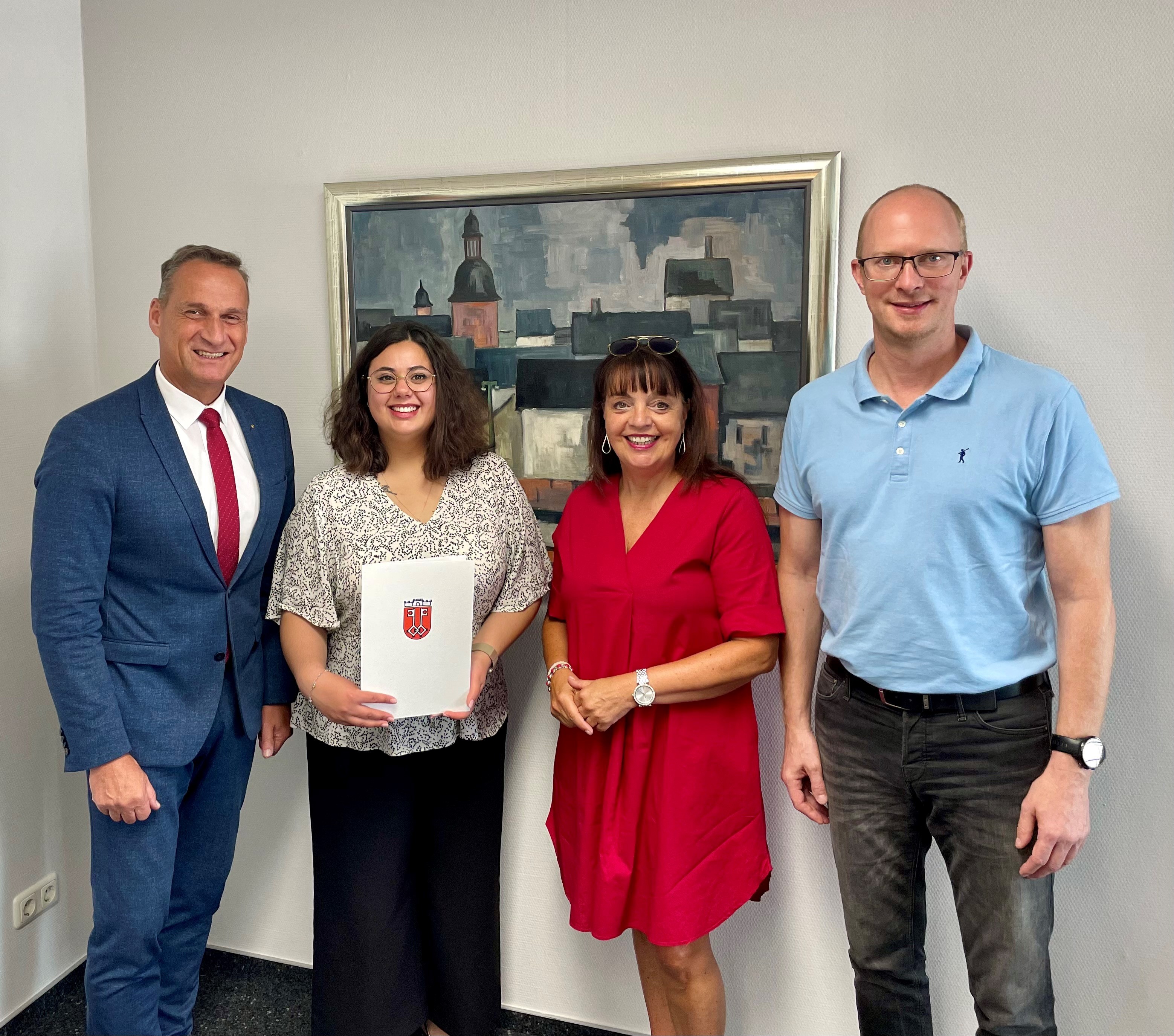 Das Bild zeigt Malika Safari mit Bürgermeister Rodenkirch, Fachbereichsleiter Jan Mußweiler und Personalratsvorsitzende Christiane Schmitz-Hayer bei der Übergabe der Ernennungsurkunde.