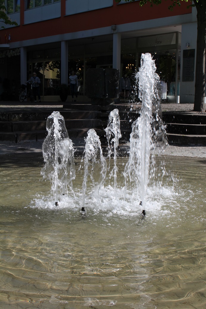 Das Foto zeigt die Fontänen des Brunnens am Platz an der Lieser.