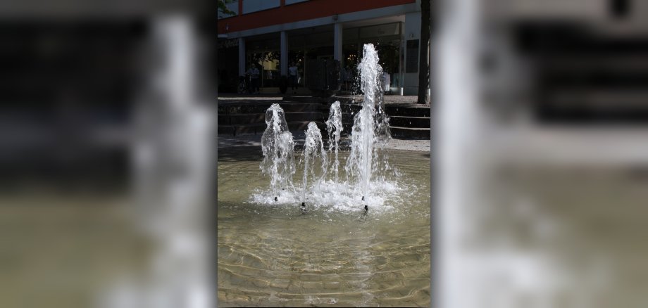 Das Foto zeigt die Fontänen des Brunnens am Platz an der Lieser.