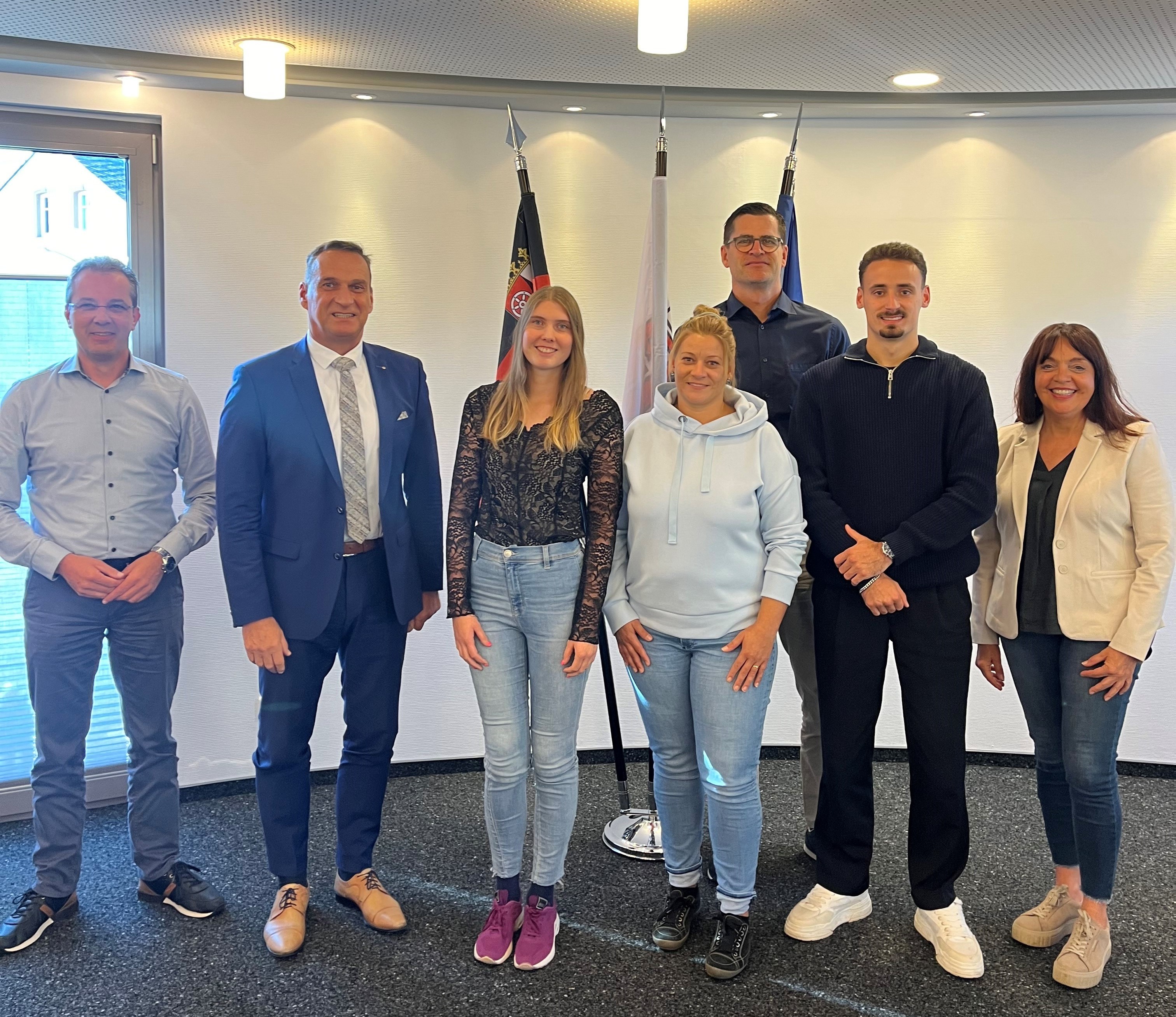 Bürgermeister Joachim Rodenkirch begrüßte die neuen Mitarbeiter*innen Meike Schneider (4. v. r.), Angelina Baum (3. v. l.) und Julius Benz (2. v. r.) und wünschte ihnen für ihre künftigen Aufgaben viel Erfolg. Der Gratulation schloss sich der Sachgebietsleiter Michael Schmitt (3. v. r.), der Leiter der Personalverwaltung Wolfgang Lauer (1. v. l.) sowie die Personalratsvorsitzende Christiane Schmitz-Hayer (1. v. r) gerne an.