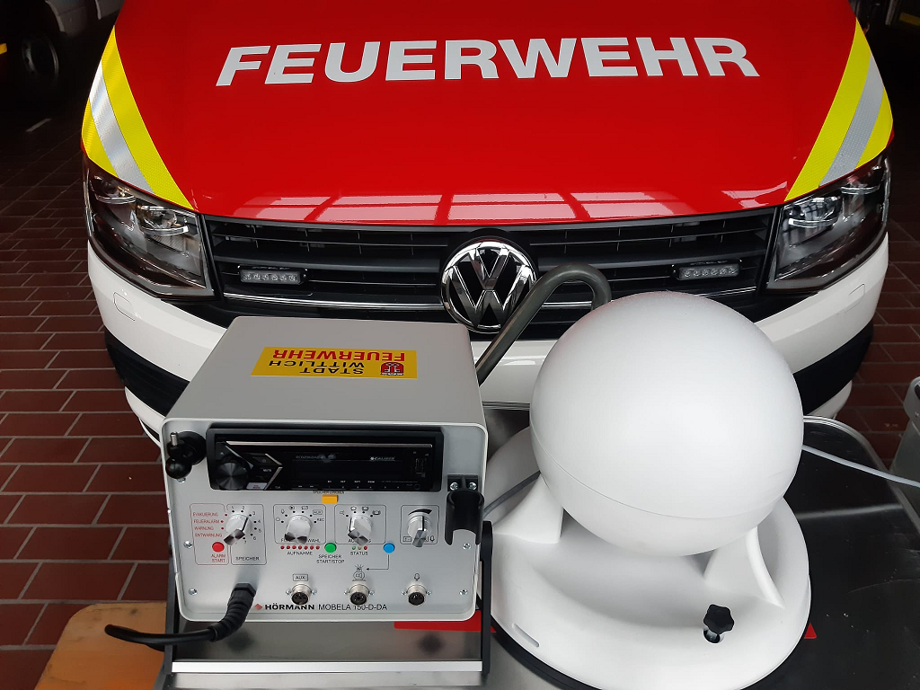 Die mobile Sirenenanlage besteht aus einem kompakten leicht bedienbaren Steuergerät und einem rundum abstrahlenden Spezial-Kugellautsprechersystem. Der Lautsprecher wird einfach auf dem Fahrzeugdach montiert. Das Steuergerät befindet sich im Fahrzeuginneren. Gegenüber herkömmlichen mobilen Sirenenanlagen, die nur Sirenensignale und Warntöne wiedergeben können, bietet die MOBELA auch die Möglichkeit, mit Hilfe eines Mikrofons Warnungen und Sprachdurchsagen wiederzugeben. Dieses System soll anlässlich des Warntages 2022 erstmals öffentlich zum Einsatz kommen.