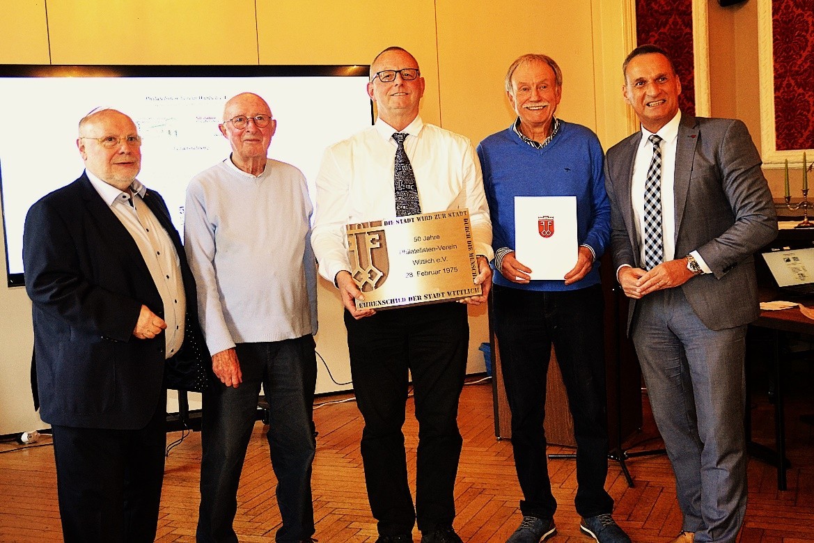Das Foto zeigt Bürgermeister Rodenkirch mit Vertretern des Philatelistenvereins bei der Übergabe des Ehrenschild der Stadt Wittlich.