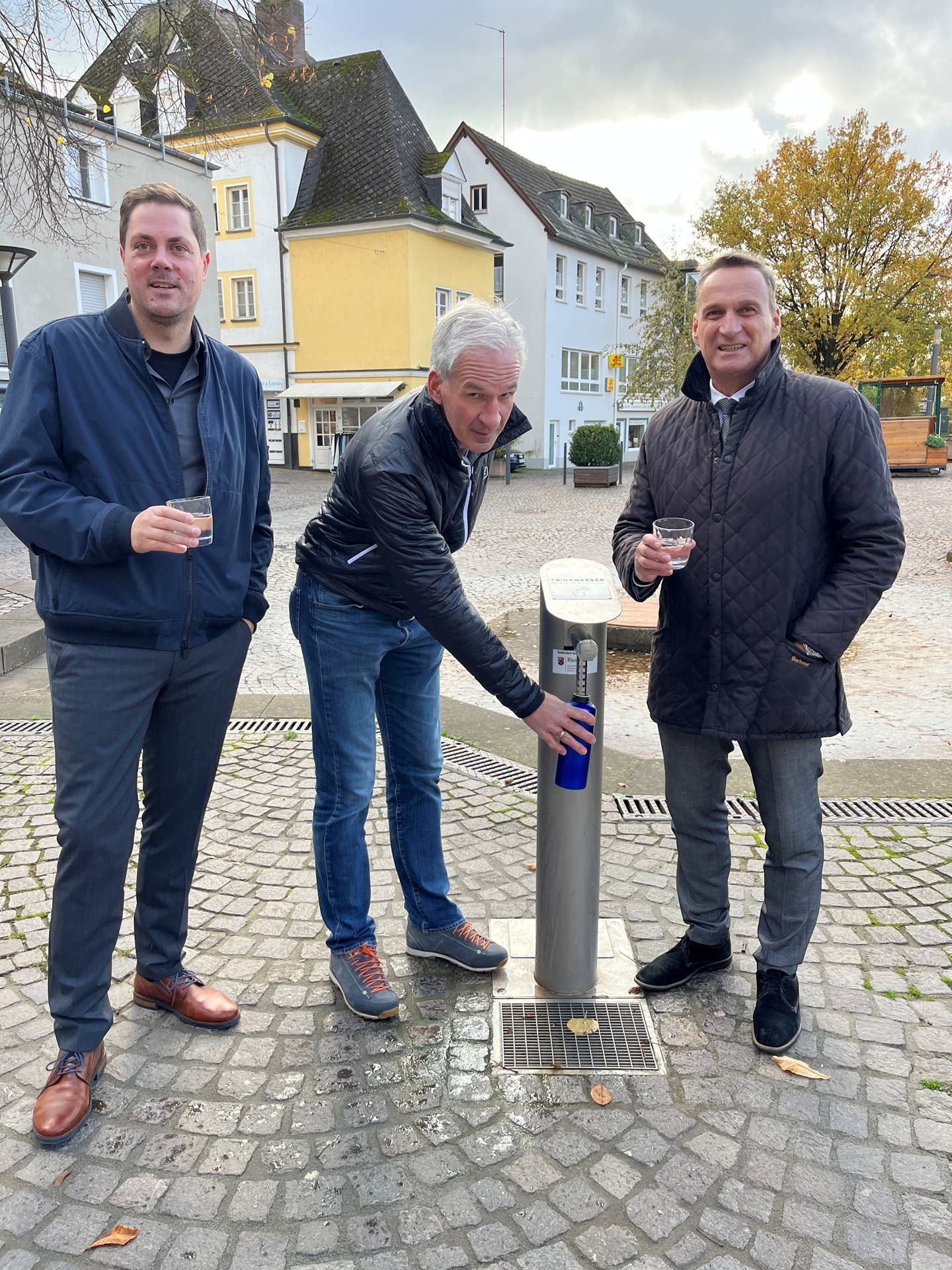 Das Foto zeigt Bürgermeister Rodenkirch mit Vertretern der Stadtwerke am neuen Trinkwasserbrunnen am Platz an der Lieser.