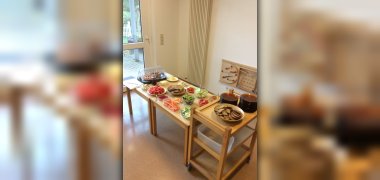 Auf dem Bild ist ein Buffet zu sehen. Es steht ein Tisch in der Wiesengruppe, auf dem Lebensmittel angerichtet wurden.