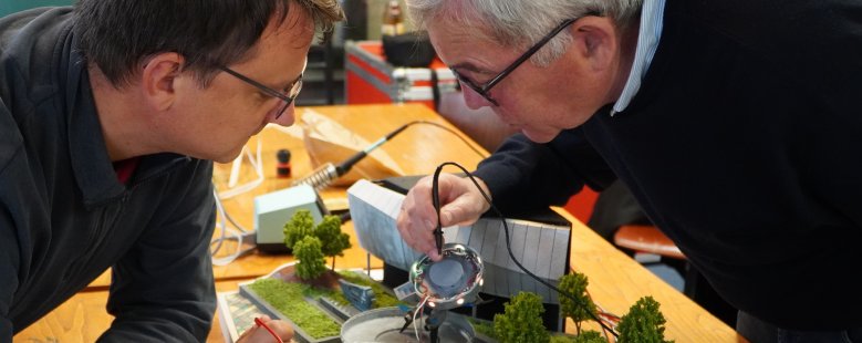 Zwei Männer arbeiten an einem Diorama