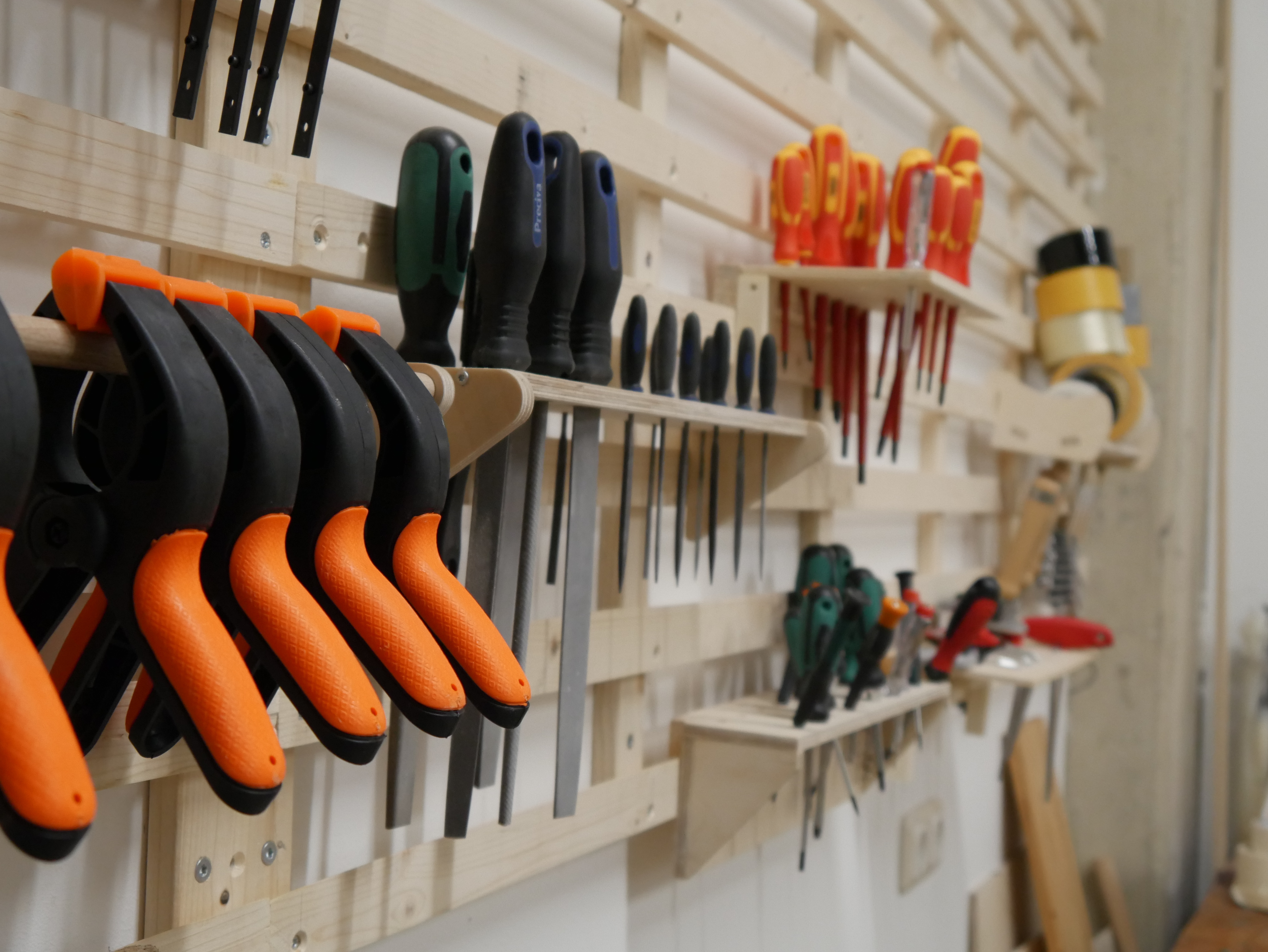 Verschiedene Werkzeuge hängen an einer Wand.